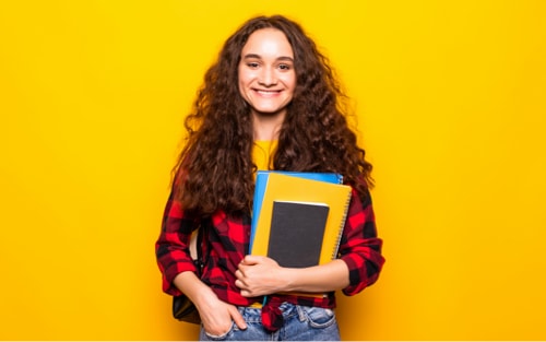 Frau mit langen Haaren hält Bücher und Hefter in der Hand